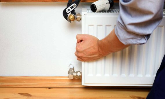 persona arreglando radiador de casa con herramienta para aflojar tuercas